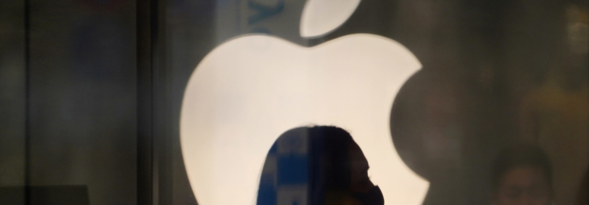 A employee wearing a protective mask is silhouetted while standing in front of an Apple Inc. logo at the company's store, temporarily closed due to the coronavirus, in the Ginza area of Tokyo, Japan, on Sunday, March 15, 2020. Apple Inc. said on March 14 it's closing its hundreds of retail stores outside of Greater China until March 27 and is moving to remote work in order to help reduce the spread of coronavirus. Photographer: Toru Hanai/Bloomberg via Getty Images