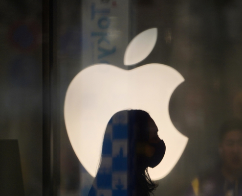 A employee wearing a protective mask is silhouetted while standing in front of an Apple Inc. logo at the company's store, temporarily closed due to the coronavirus, in the Ginza area of Tokyo, Japan, on Sunday, March 15, 2020. Apple Inc. said on March 14 it's closing its hundreds of retail stores outside of Greater China until March 27 and is moving to remote work in order to help reduce the spread of coronavirus. Photographer: Toru Hanai/Bloomberg via Getty Images